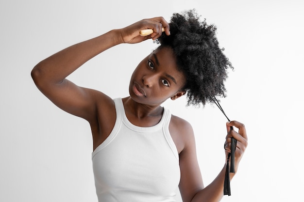 Mujer joven peinando el cabello vista frontal