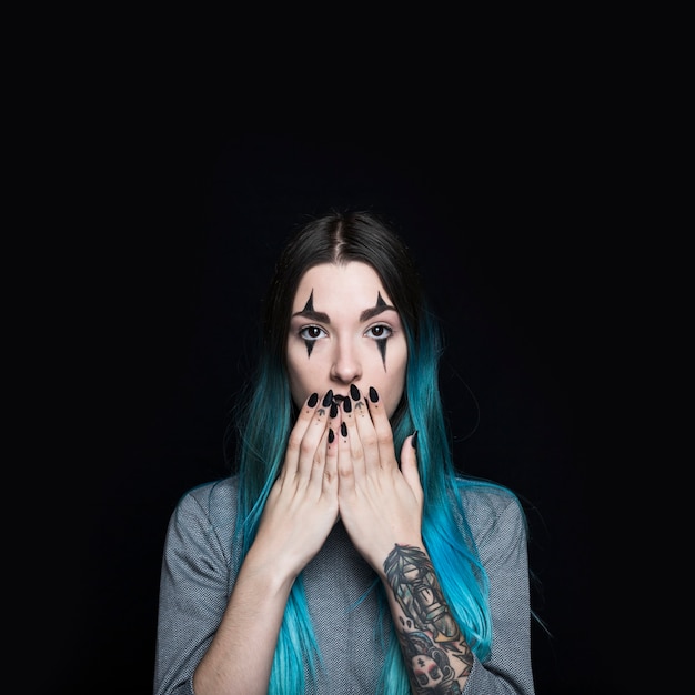 Foto gratuita mujer joven con pelo largo azul cerrando la boca con las manos