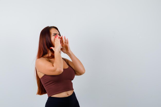 Mujer joven, con, pelo largo, llevando, ropa deportiva, gritos