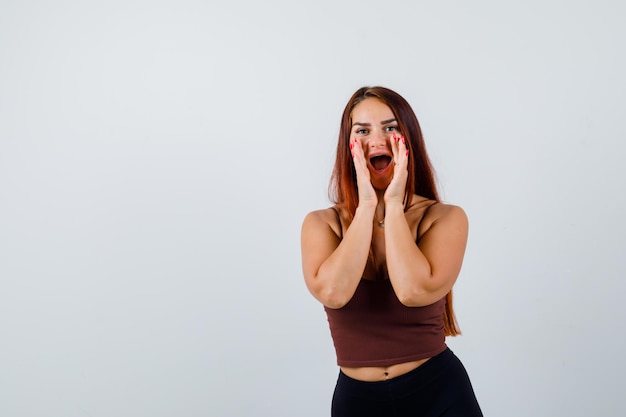 Mujer joven, con, pelo largo, llevando, ropa deportiva, gritos