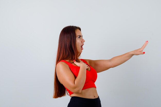 Mujer joven, con, pelo largo, en, un, naranja, camiseta sin mangas