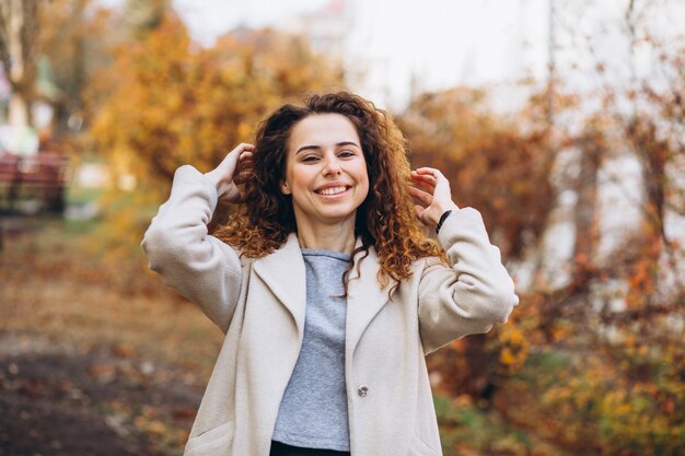 Foto gratuita mujer joven con pelo rizado en el parque