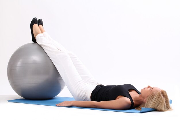 Mujer joven con pelota de fitness