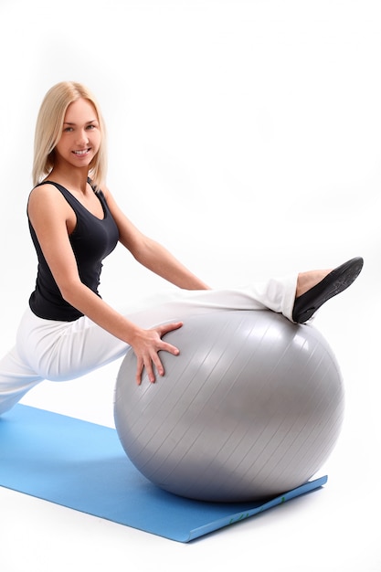 Mujer joven con pelota de fitness