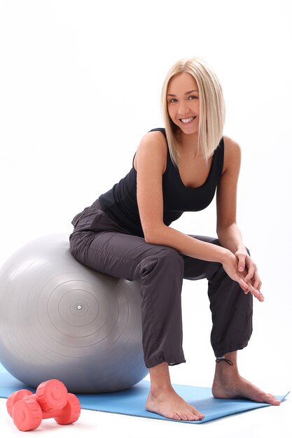 Mujer joven con pelota de fitness