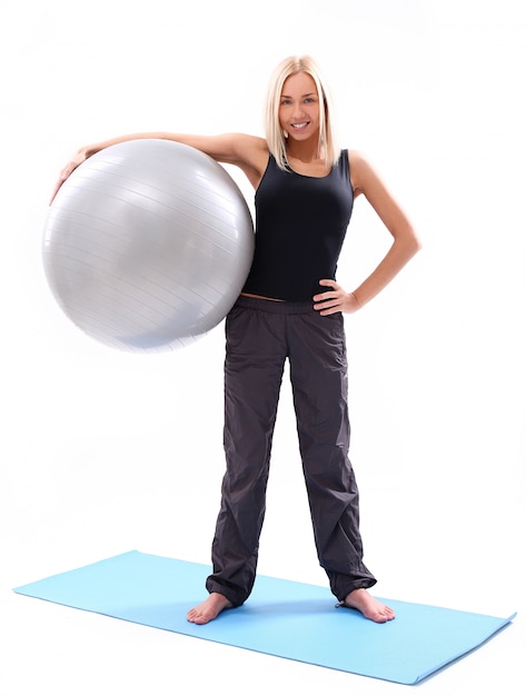 Mujer joven con pelota de fitness