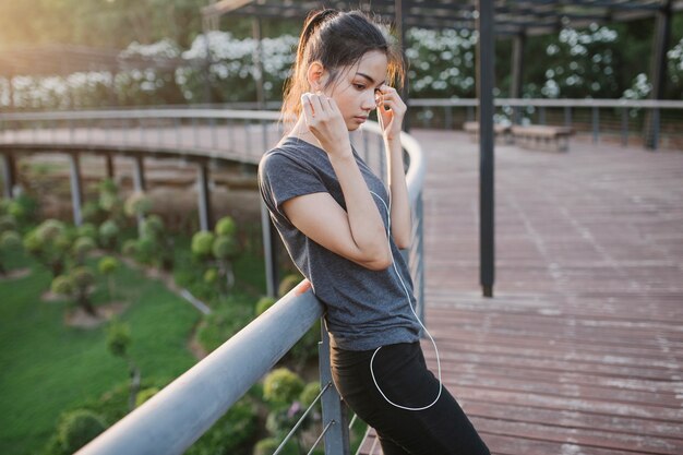 Mujer joven pensativa escuchando música al aire libre