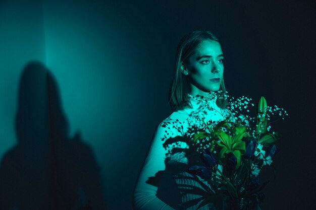 Mujer joven pensativa con flores