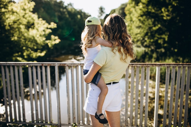 Mujer joven con pequeña hija caminando en el parque