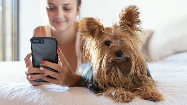 Mujer joven con perro tomando selfie