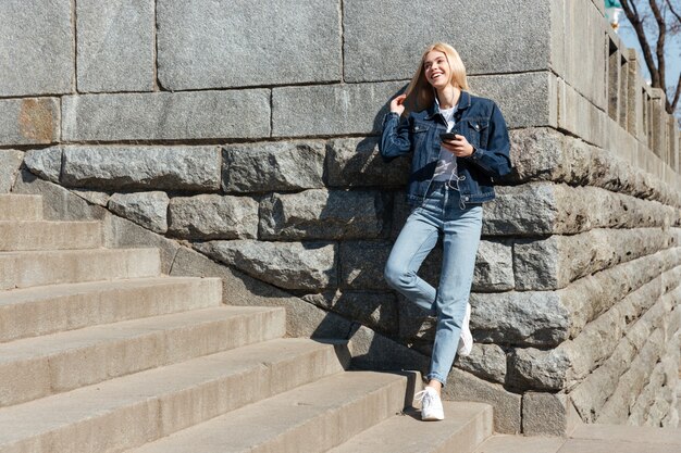 Mujer joven con pie casual en las escaleras en la calle