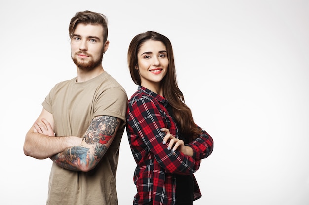 Mujer y joven de pie de espaldas mirando directamente.