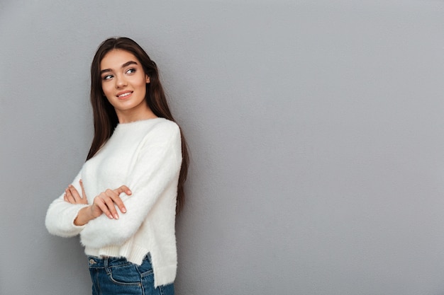 Foto gratuita mujer joven de pie en la pared gris