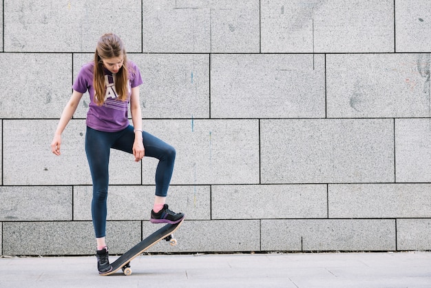 Mujer joven de pie con patineta