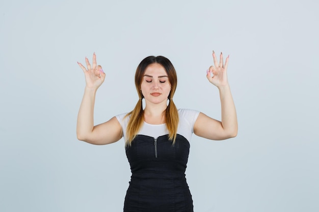 Mujer joven de pie en pose de meditación