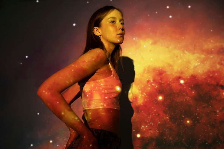 Foto gratuito mujer joven de pie en la proyección de textura del universo