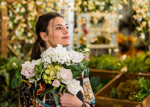 Mujer joven de pie con ramo de flores