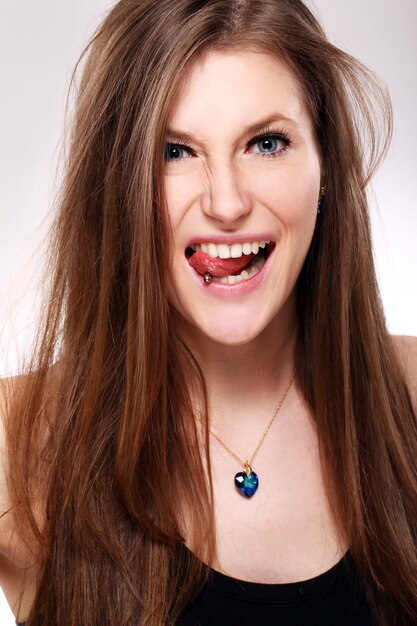 Mujer joven con piercing en la lengua