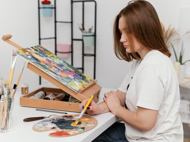 Mujer joven pintando con acrílicos