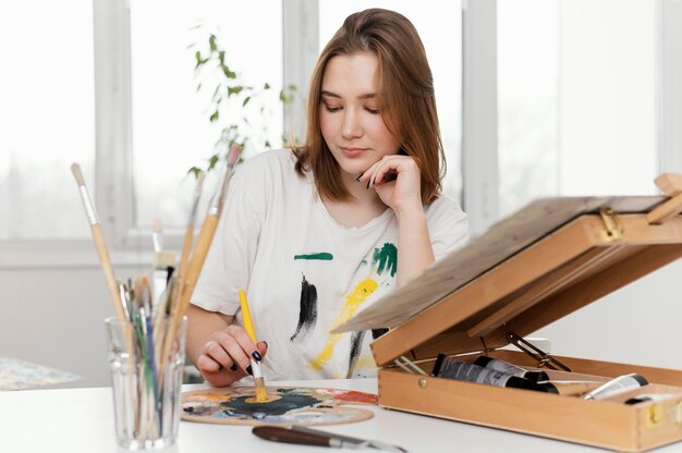 Mujer joven pintando con acrílicos