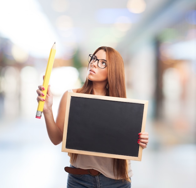 Mujer joven con la pizarra y el lápiz