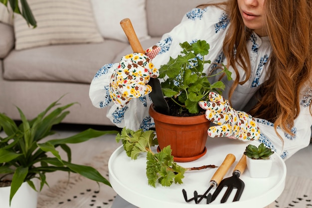 Mujer joven plantar en casa con herramientas