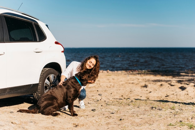 Foto gratuita mujer joven en la playa con su perro