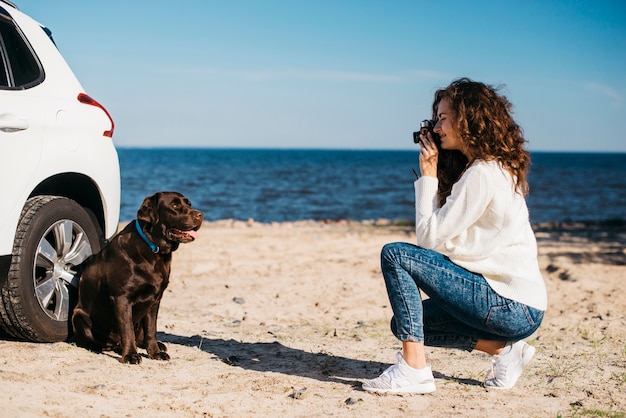 Mujer joven en la playa con su perro