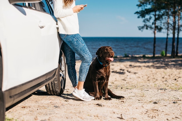 Mujer joven en la playa con su perro