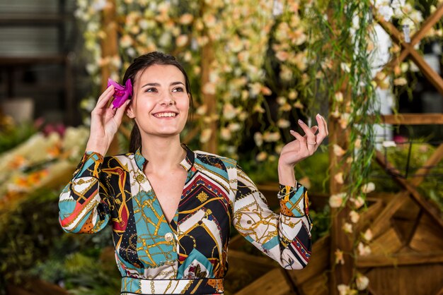 Mujer joven, poniendo, flor, en, pelo