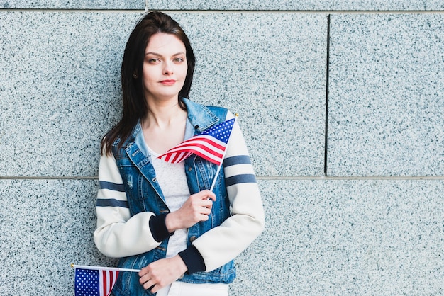 Mujer joven posando con banderas americanas