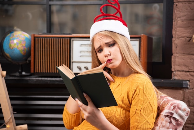 Mujer joven posando con caja de regalo de Navidad.