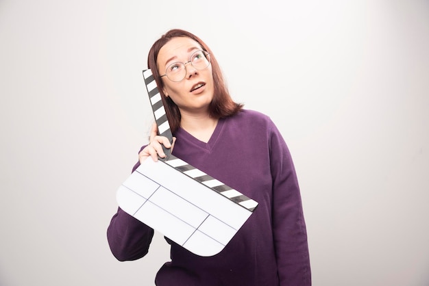 Foto gratuita mujer joven posando con una cinta de cine sobre un fondo blanco. foto de alta calidad