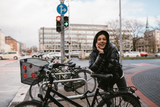 Mujer joven posando en un estacionamiento con bicicletas