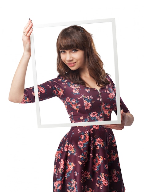 Mujer joven posando con un marco grande