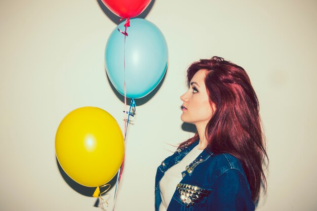 Mujer joven posando de perfil con globos