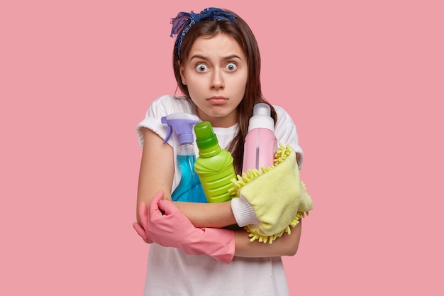 Mujer joven posando con productos de limpieza