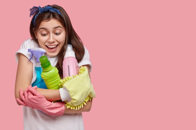 Mujer joven posando con productos de limpieza