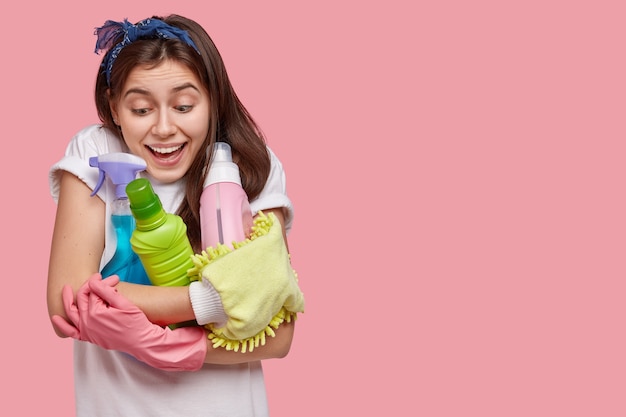 Mujer joven posando con productos de limpieza