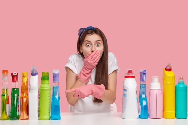 Mujer joven posando con productos de limpieza