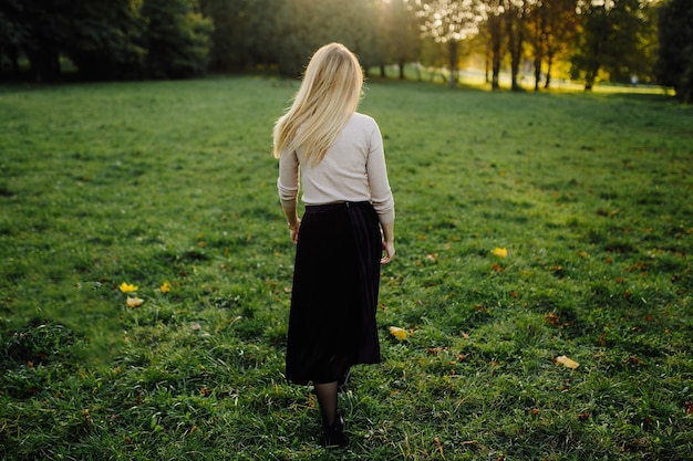 Mujer Joven Posando Sobre Hojas Amarillas En El Parque De Otoño. Al aire libre