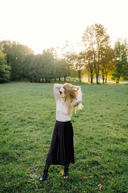 Mujer Joven Posando Sobre Hojas Amarillas En El Parque De Otoño. Al aire libre