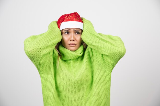 Foto gratuita mujer joven posando con sombrero rojo de santa claus.