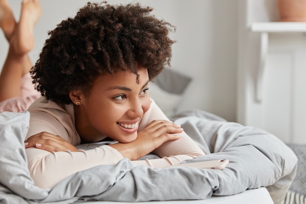 mujer joven, posar, en casa, en, cómodo, cama