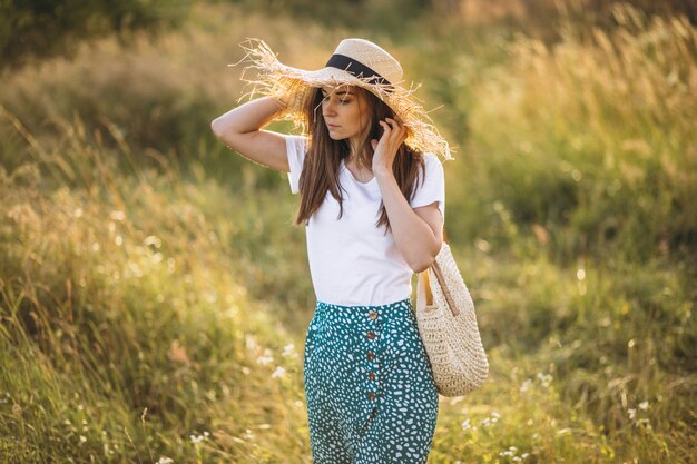 Mujer joven, posición, con, bolsa, en, sombrero grande, en, campo