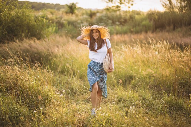 Mujer joven, posición, con, bolsa, en, sombrero grande, en, campo