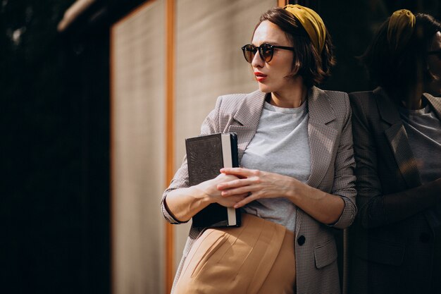 Mujer joven, posición, con, libro, aire libre