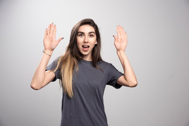 Mujer joven, posición, y, posar, con, manos arriba