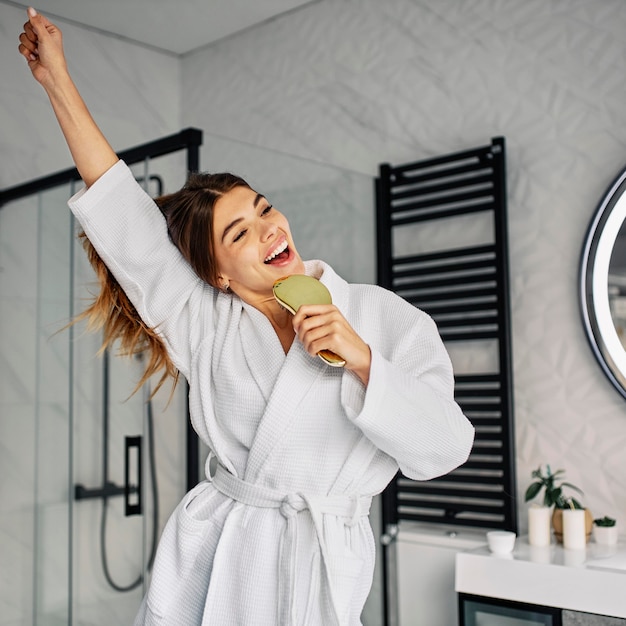 Mujer joven positiva en bata de baño