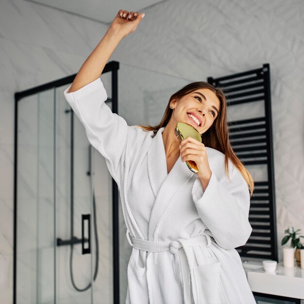 Mujer joven positiva en bata de baño